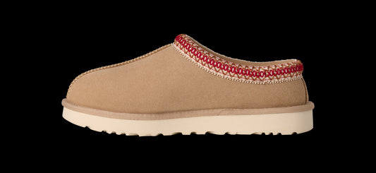Tan slipper with red trim on a white background