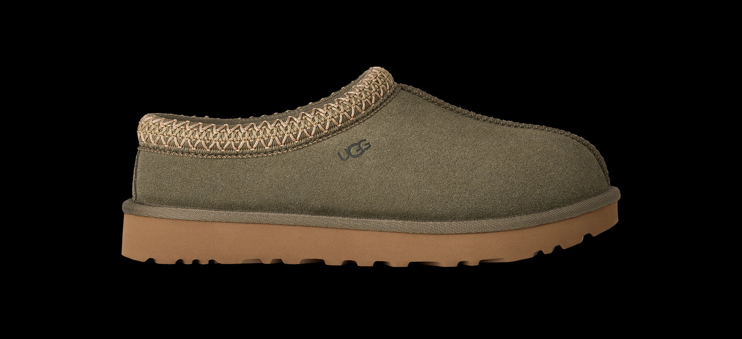 Green slipper with brown sole on a white background